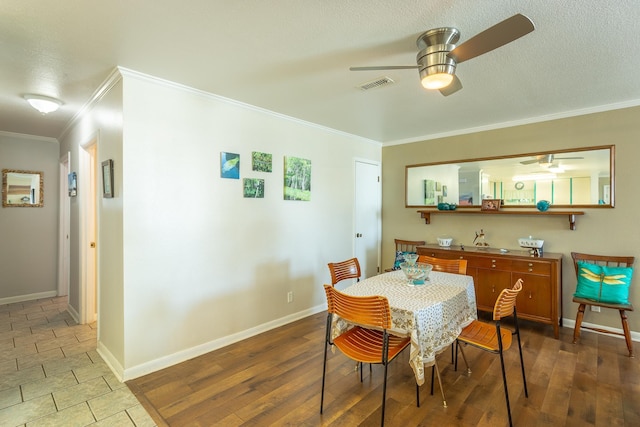 dining room with a textured ceiling, hardwood / wood-style flooring, ceiling fan, and crown molding