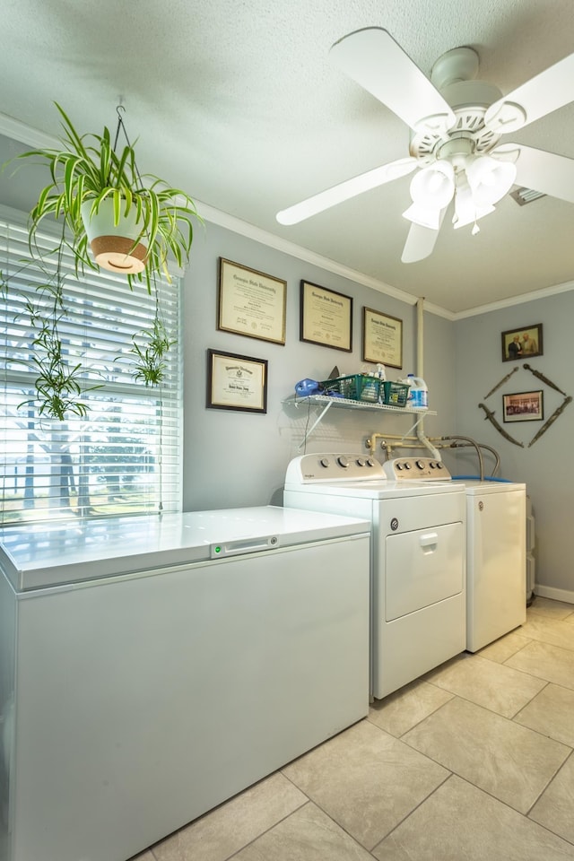 laundry room with ornamental molding, a textured ceiling, washer and clothes dryer, ceiling fan, and light tile patterned flooring