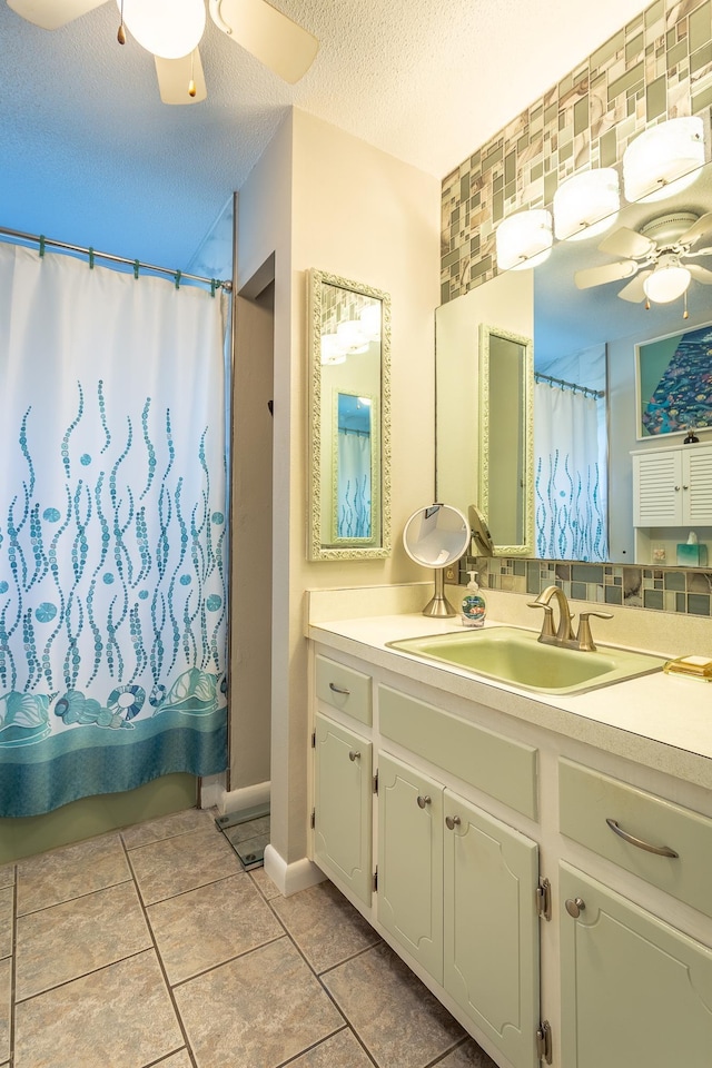 bathroom featuring tile patterned flooring, decorative backsplash, a textured ceiling, and vanity