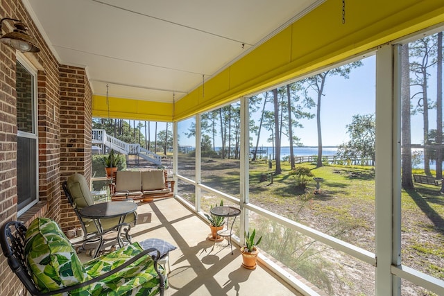 sunroom featuring a water view and a wealth of natural light