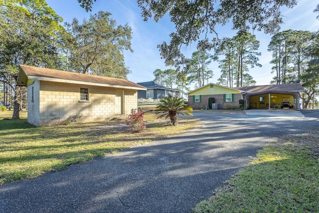 view of front of property with a carport and a front lawn