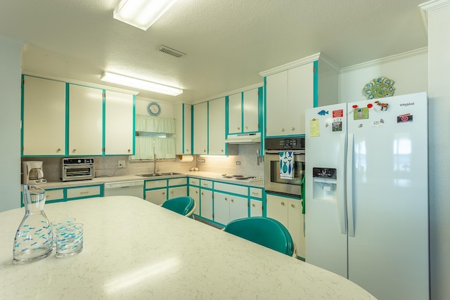 kitchen with decorative backsplash, sink, white appliances, and ornamental molding