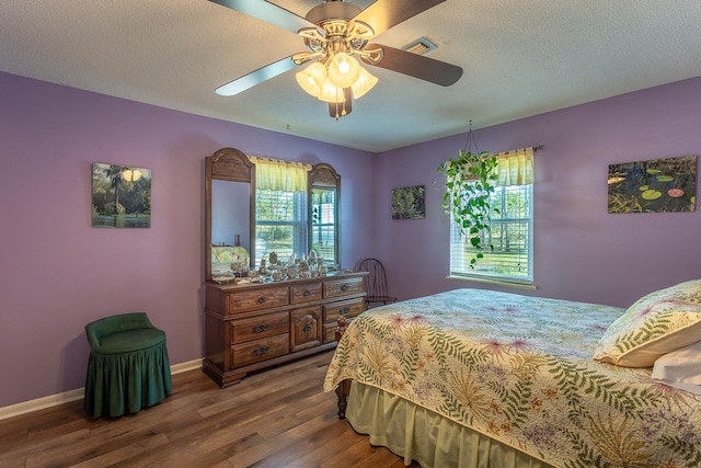 bedroom with wood-type flooring, a textured ceiling, and ceiling fan