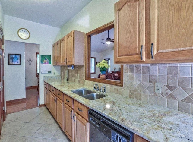 kitchen with sink, dishwasher, tasteful backsplash, light stone countertops, and light tile patterned flooring