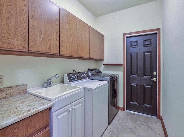 laundry area featuring cabinets, washing machine and dryer, sink, and light tile patterned floors