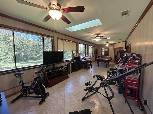 exercise room with ornamental molding and a skylight