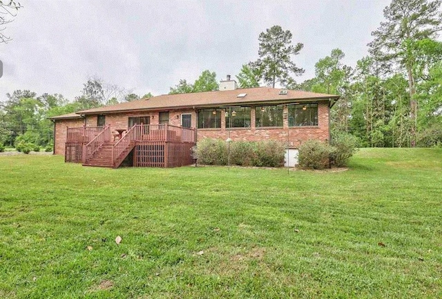 ranch-style house featuring a wooden deck and a front lawn