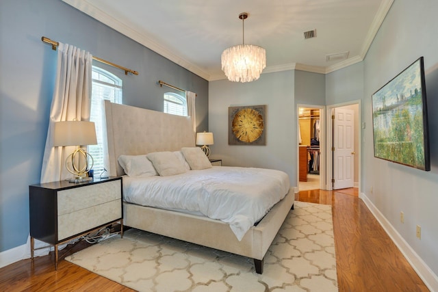 3690 Dexter Dr, Tallahassee, FL 32312 - bedroom featuring wood finished floors, crown molding, a chandelier, and a spacious closet
