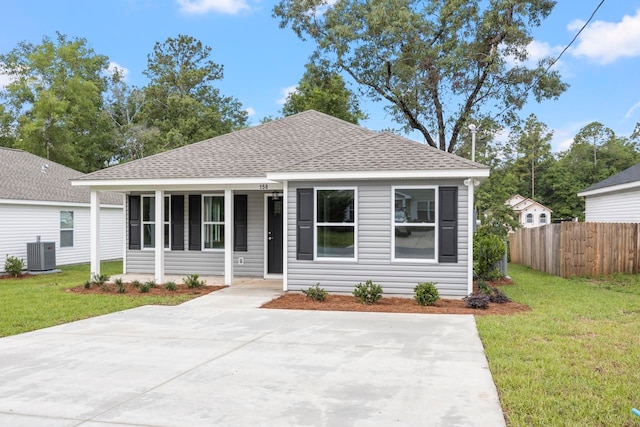 bungalow-style house with a front yard and central AC unit