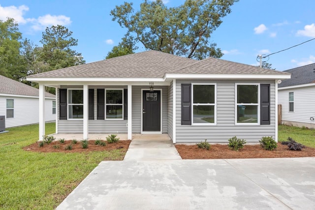 bungalow-style home featuring central AC unit and a front yard