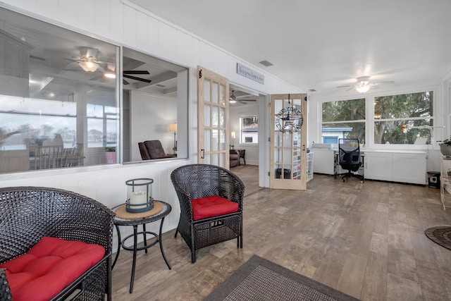 living area with hardwood / wood-style flooring and crown molding