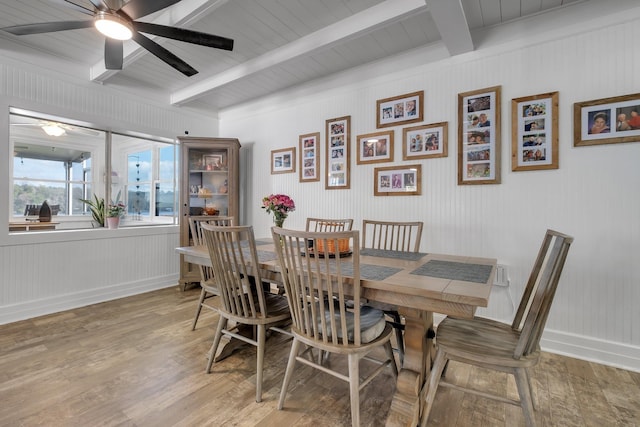 dining space with beam ceiling, hardwood / wood-style flooring, and ceiling fan