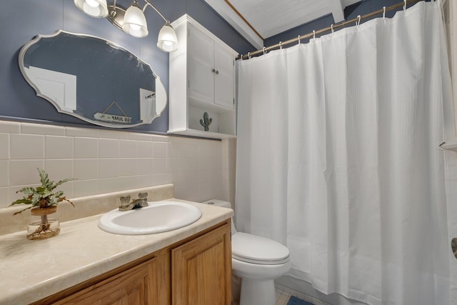 bathroom featuring vanity, toilet, and tile walls