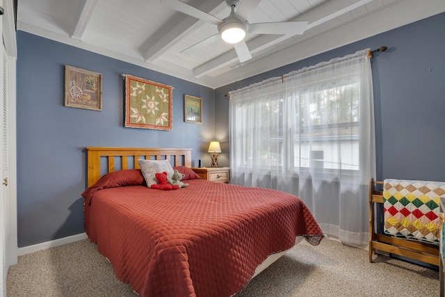 carpeted bedroom with beamed ceiling and ceiling fan