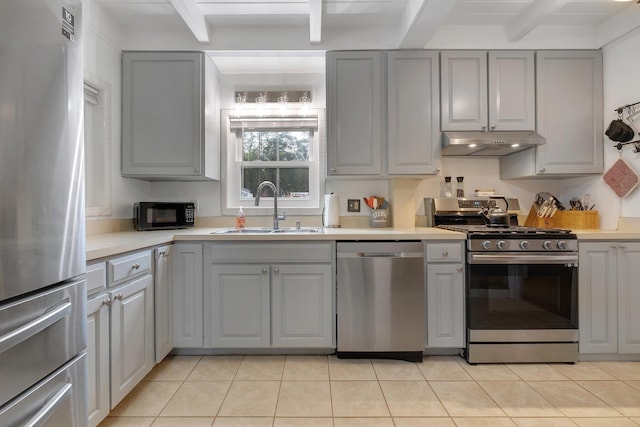 kitchen with beamed ceiling, stainless steel appliances, sink, and gray cabinetry