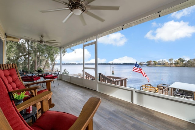 sunroom with a water view and ceiling fan