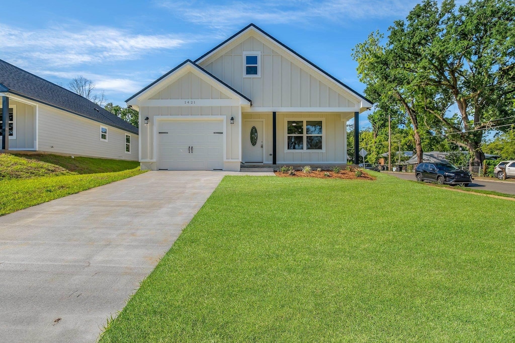 1421 Stuckey Ave, Tallahassee, FL 32310 - modern farmhouse with board and batten siding, driveway, a garage, and a front yard