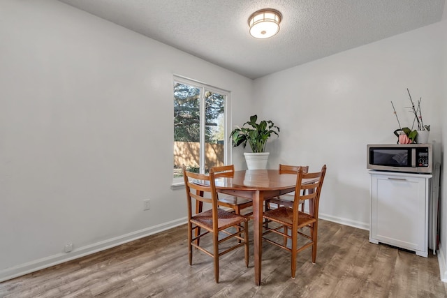 dining room featuring hardwood / wood-style floors and a textured ceiling