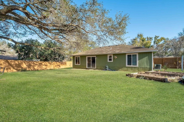 back of house featuring a yard and central air condition unit