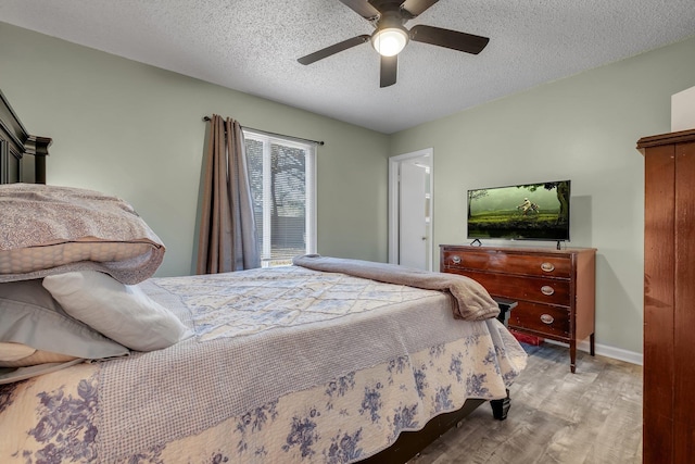 bedroom featuring ceiling fan, a textured ceiling, and light hardwood / wood-style flooring