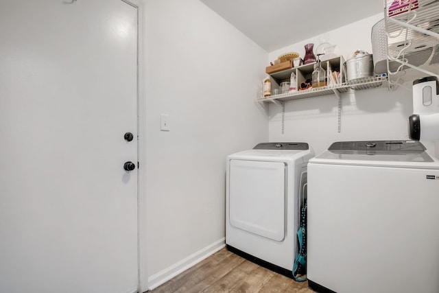 laundry room featuring washer and clothes dryer and light hardwood / wood-style flooring