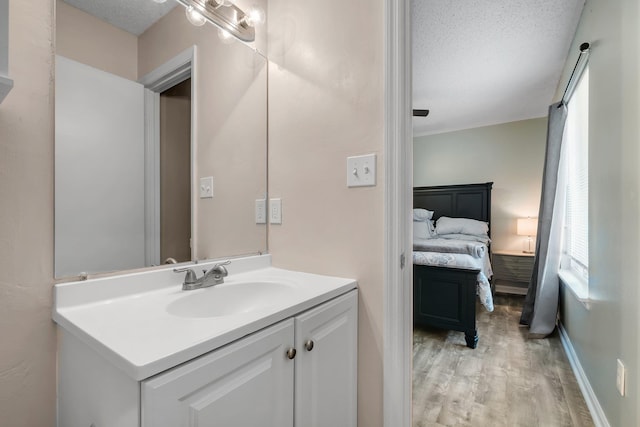 bathroom with vanity, hardwood / wood-style floors, and a textured ceiling