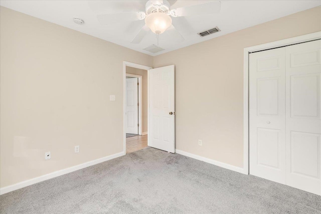 unfurnished bedroom with ceiling fan, a closet, and light colored carpet