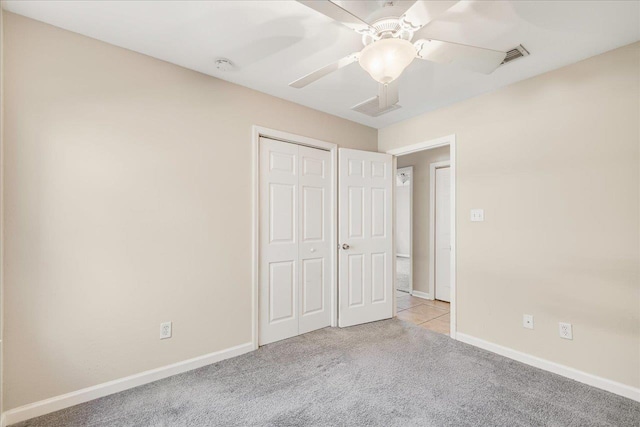 unfurnished bedroom with ceiling fan, light colored carpet, and a closet