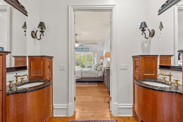 bathroom featuring wood finished floors, a ceiling fan, crown molding, and vanity