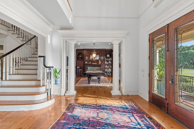 foyer with ornate columns, billiards, hardwood / wood-style flooring, and stairs