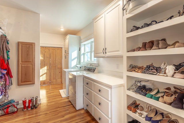 clothes washing area featuring washer and dryer and light hardwood / wood-style flooring