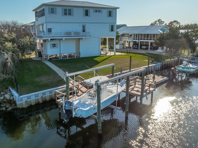 view of dock featuring a lawn and a water view