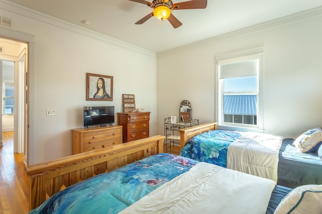 bedroom with multiple windows, hardwood / wood-style flooring, ceiling fan, and ornamental molding