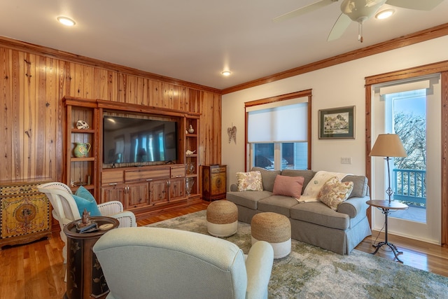 living room featuring crown molding, plenty of natural light, ceiling fan, and wood-type flooring