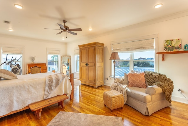 bedroom with ceiling fan, light hardwood / wood-style floors, and ornamental molding