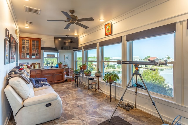 sunroom / solarium featuring ceiling fan and sink