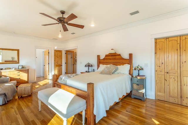 bedroom featuring hardwood / wood-style floors, ceiling fan, and ornamental molding