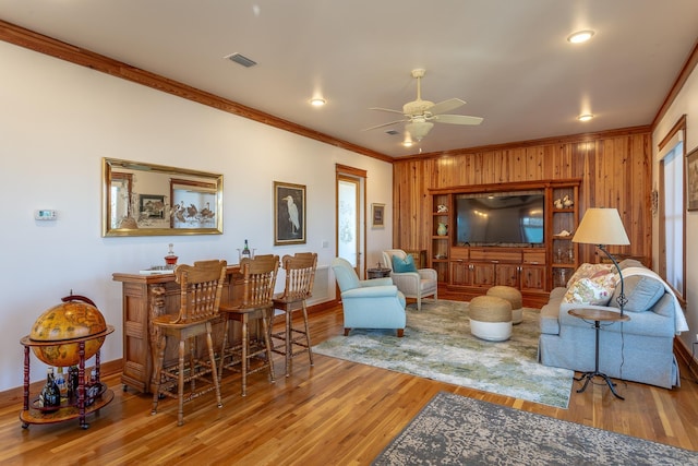 living room featuring ceiling fan, light hardwood / wood-style flooring, and ornamental molding