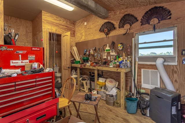 misc room with a workshop area, wood walls, and beamed ceiling