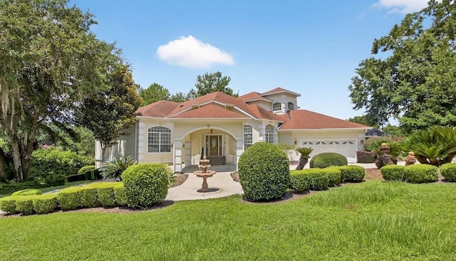7502 Refuge Rd, Tallahassee, FL 32312 - mediterranean / spanish-style house with an attached garage, a front yard, and stucco siding