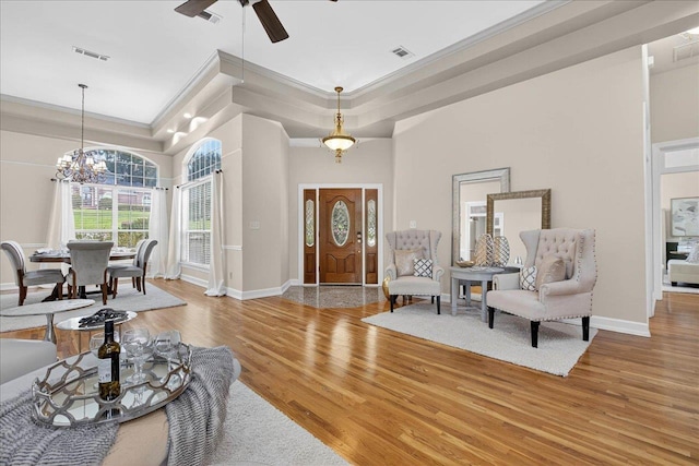 7502 Refuge Rd, Tallahassee, FL 32312 - foyer featuring a raised ceiling, light wood-type flooring, ornamental molding, ceiling fan, and a chandelier