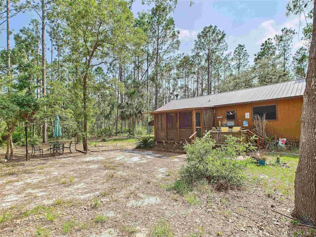 18722 Key Deer Ct, Keaton Beach, FL 32348 - rear view of house featuring a sunroom, metal roof, and view of wooded area