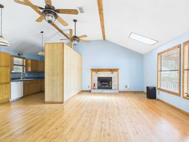 18722 Key Deer Ct, Keaton Beach, FL 32348 - unfurnished living room with light wood-type flooring, a stone fireplace, a ceiling fan, a skylight, and a sink