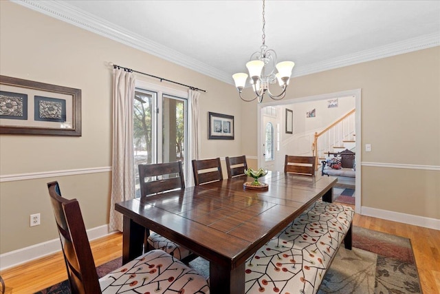 231 Sheline Dr, Havana, FL 32333 - dining room featuring light wood-style flooring, a chandelier, ornamental molding, stairway, and baseboards