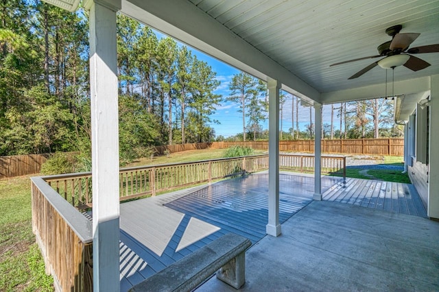 wooden terrace with ceiling fan and a lawn