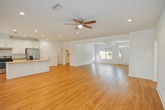 unfurnished living room with ceiling fan and light hardwood / wood-style flooring