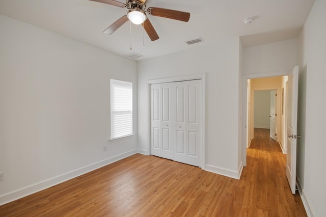 unfurnished bedroom featuring a closet, light hardwood / wood-style flooring, and ceiling fan