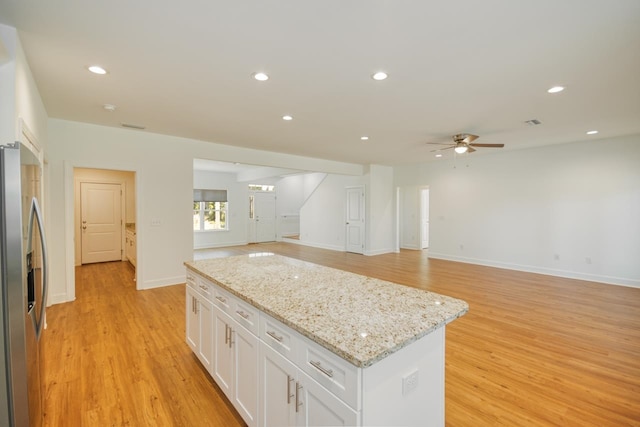 kitchen featuring white cabinets, ceiling fan, stainless steel fridge, and light hardwood / wood-style floors