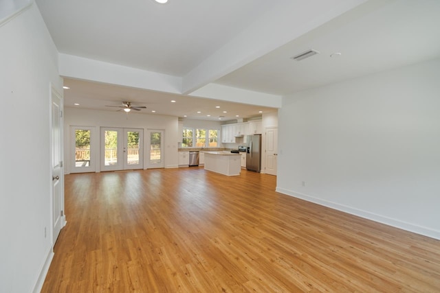 unfurnished living room featuring ceiling fan and light hardwood / wood-style floors