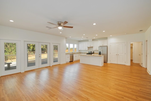 unfurnished living room featuring french doors, light hardwood / wood-style flooring, and ceiling fan